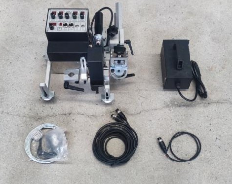 Fillet welding carriage kit laid out with its magnetic guide wheels and tools